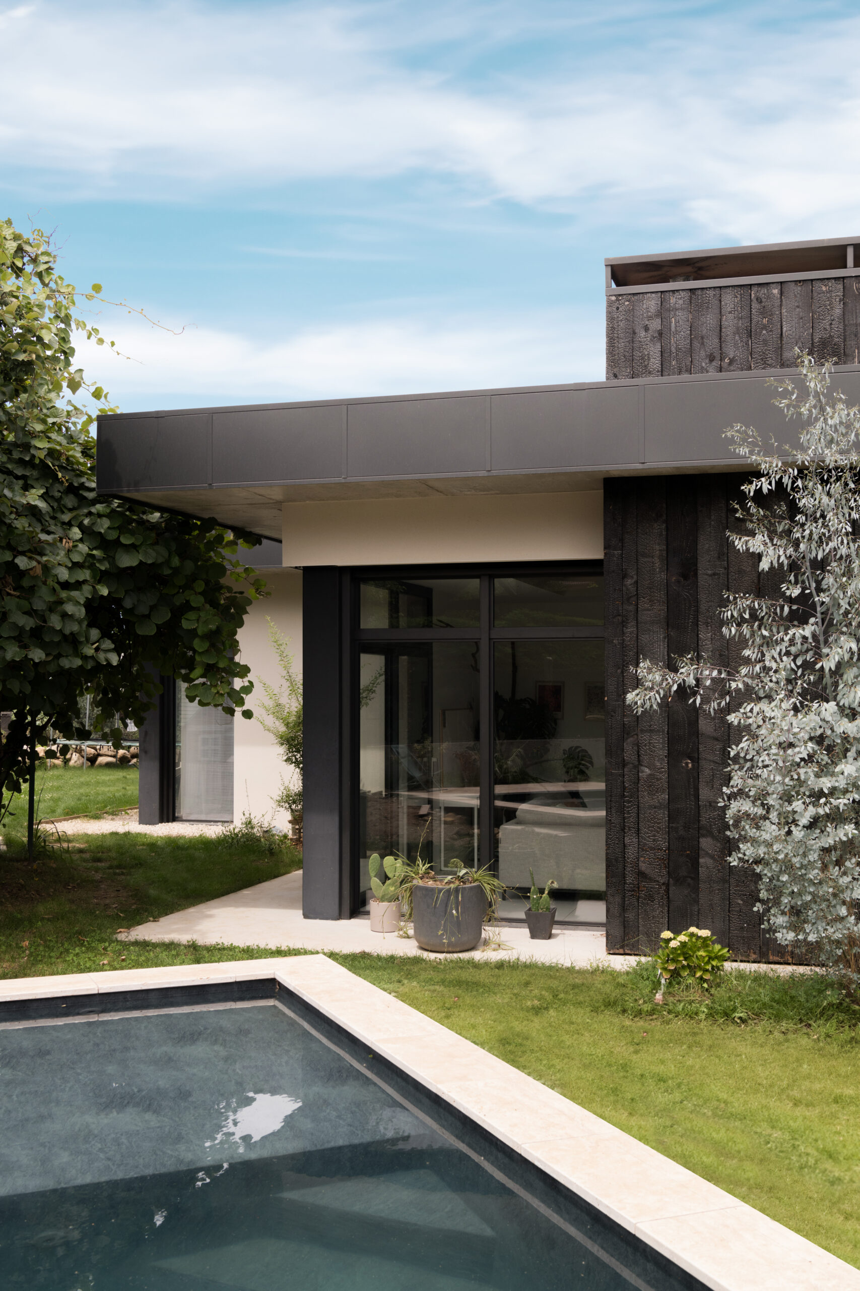 Villa contemporaine avec piscine habillé en travertin et grandes ouvertures en aluminium.