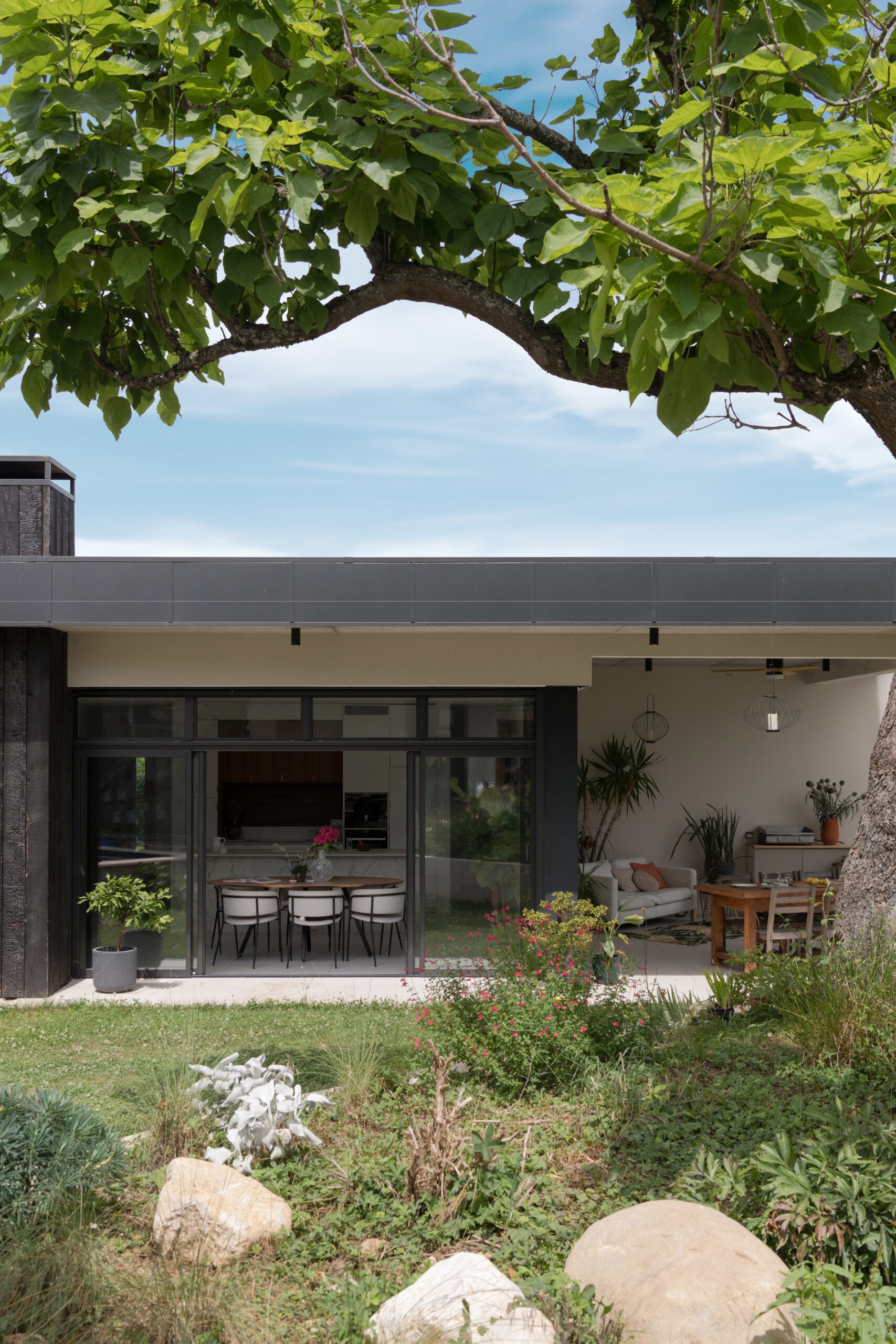 Villa contemporaine avec façade en bois brulé et terrasse couverte.